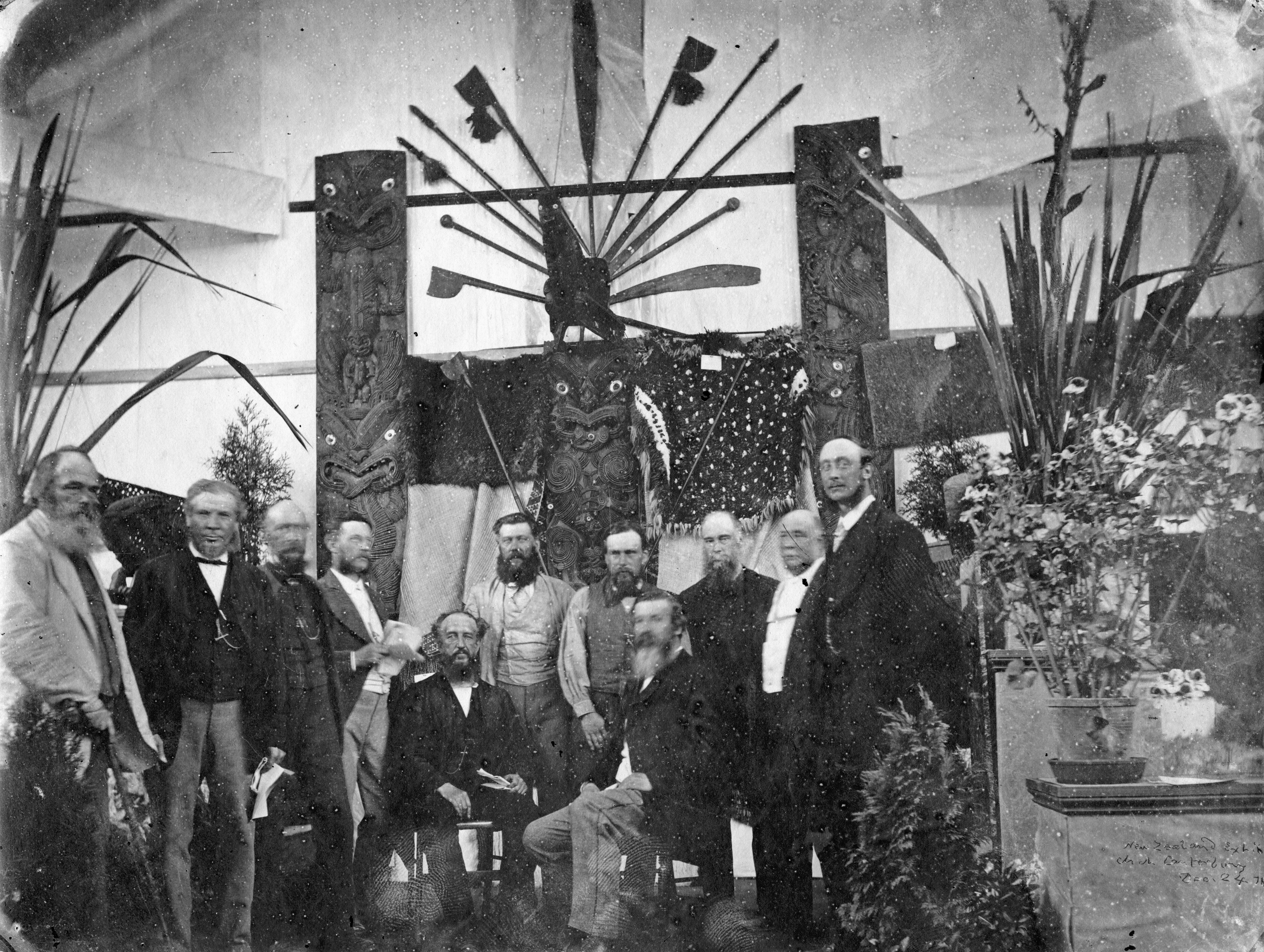 This group of men standing in front of a Māori display at the Colonial and Vienna Exhibition of 1872–3 includes Dr Alfred Charles Barker (far left), who was to die a few weeks later, John Anderson, a former Mayor of Christchurch (second from left), James Hector (fourth from left), John Davies Enys (fourth from right) and William Miles Maskell (far right). John Enys is the shortest man who is standing. Seated are the Rev Charles Fraser (left) and Julius Haast (right). The other men include Robert Heaton Rhodes, J Hansell and M B Hart (second right, a future Mayor). A C Barker photo, Canterbury Museum 1977 365 8. No known copyright restrictions