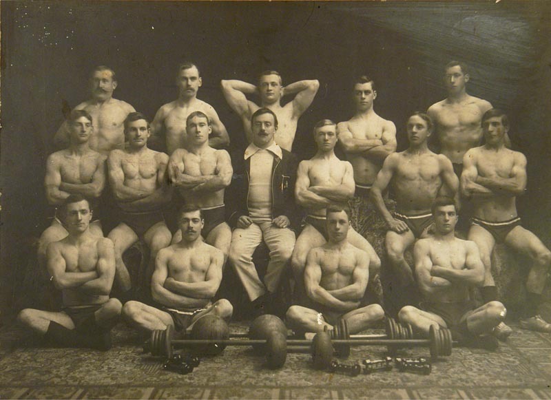 Fred Hornibrook surrounded by his students c1903. Note the spring grip dumb-bells in the foreground. 1982.283.2