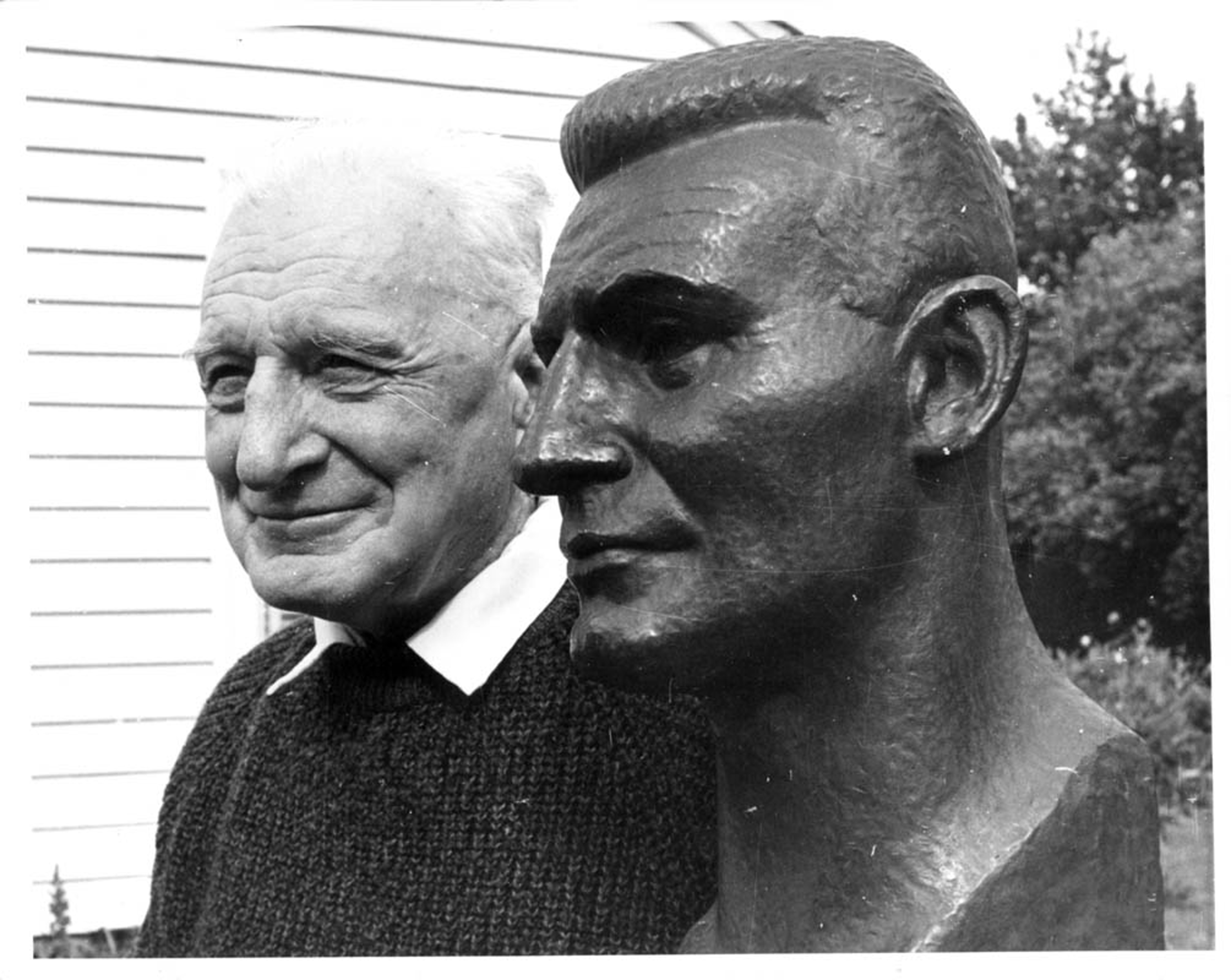 Rewi Alley and a Bronze bust of Alley by Francis A. Shurrock (1887-1977), exhibited at the Royal Academy in 1939. The original bronze cast was lost in enemy action on the way to New Zealand during World War Two. The present bust was recast and donated to Canterbury Museum in 1958 by a group of Alley's friends, including Shurrock. It was exhibited at the opening of the Hall of Oriental Art. Photo published in The Press 25 November 1971. Canterbury Museum 2007.63.70.