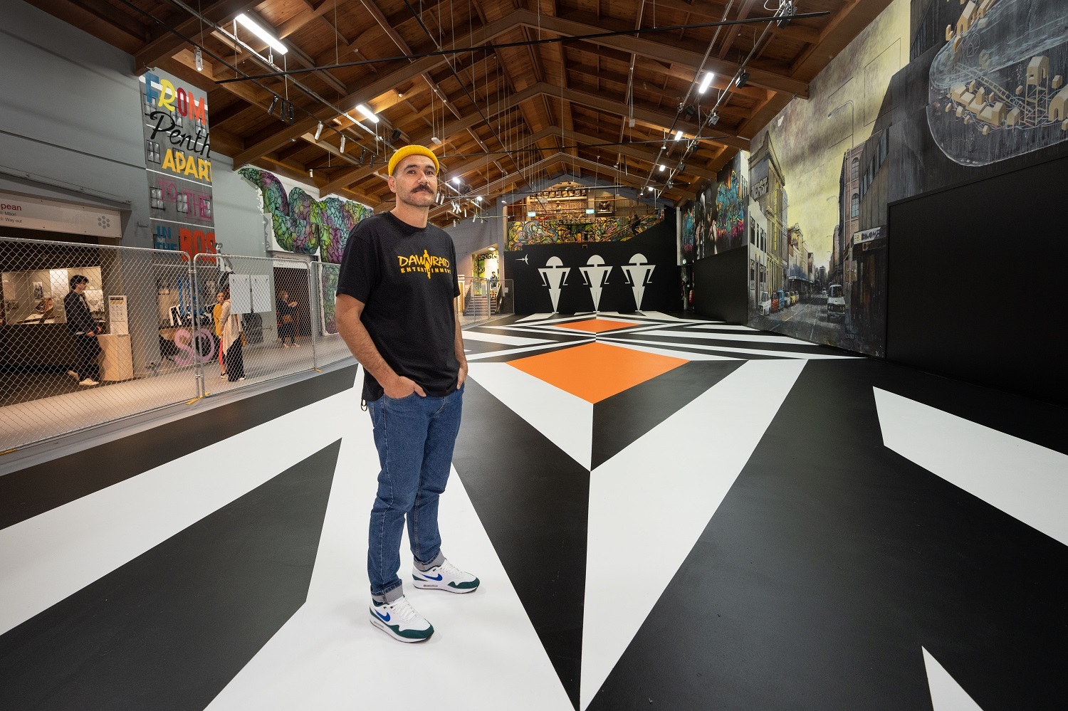 Artist Benjamin Work with his mural Motutapu II