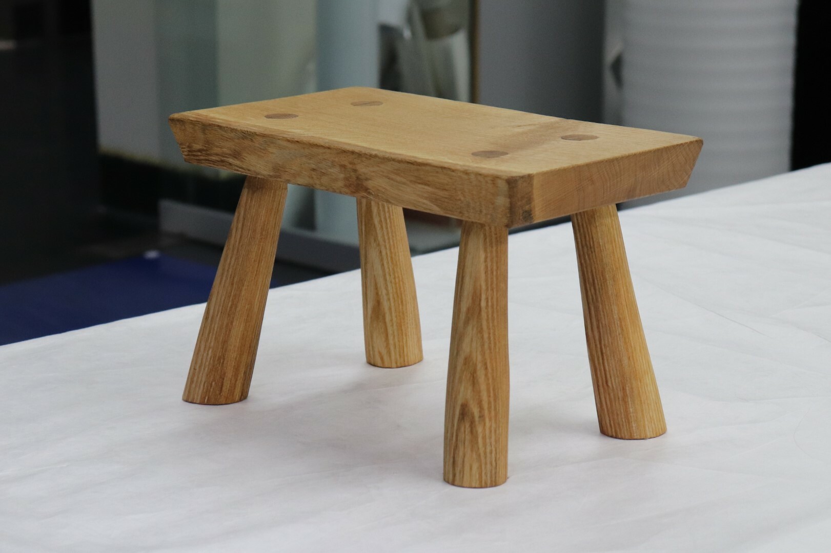 The stool made by Greg Quinn. The legs are made from an ash tree felled in Hagley Park, and the top is from an oak at Lincoln University.