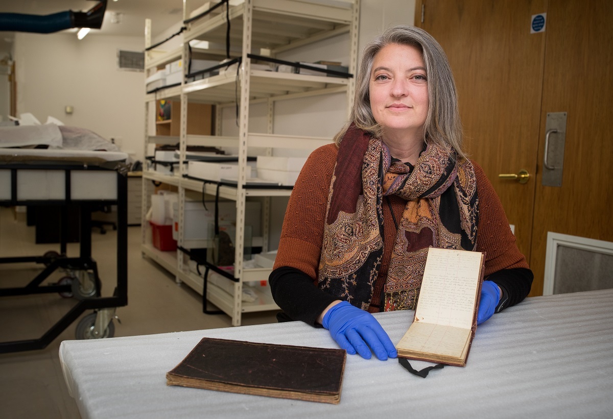 Canterbury Museum Curator Human History Jill Haley with Tryggve Gran's diaries. Image available CC BY NC and for News and Current Affairs Use