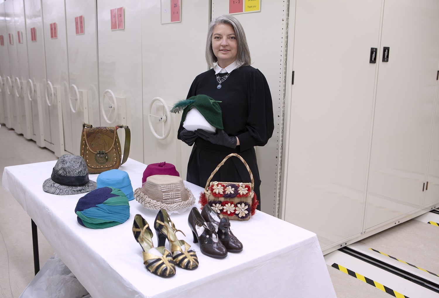 Dr Jill Haley, Curator Human History with some of the hats, bags and shoes from the Mollie Rodie Mackenzie Collection.