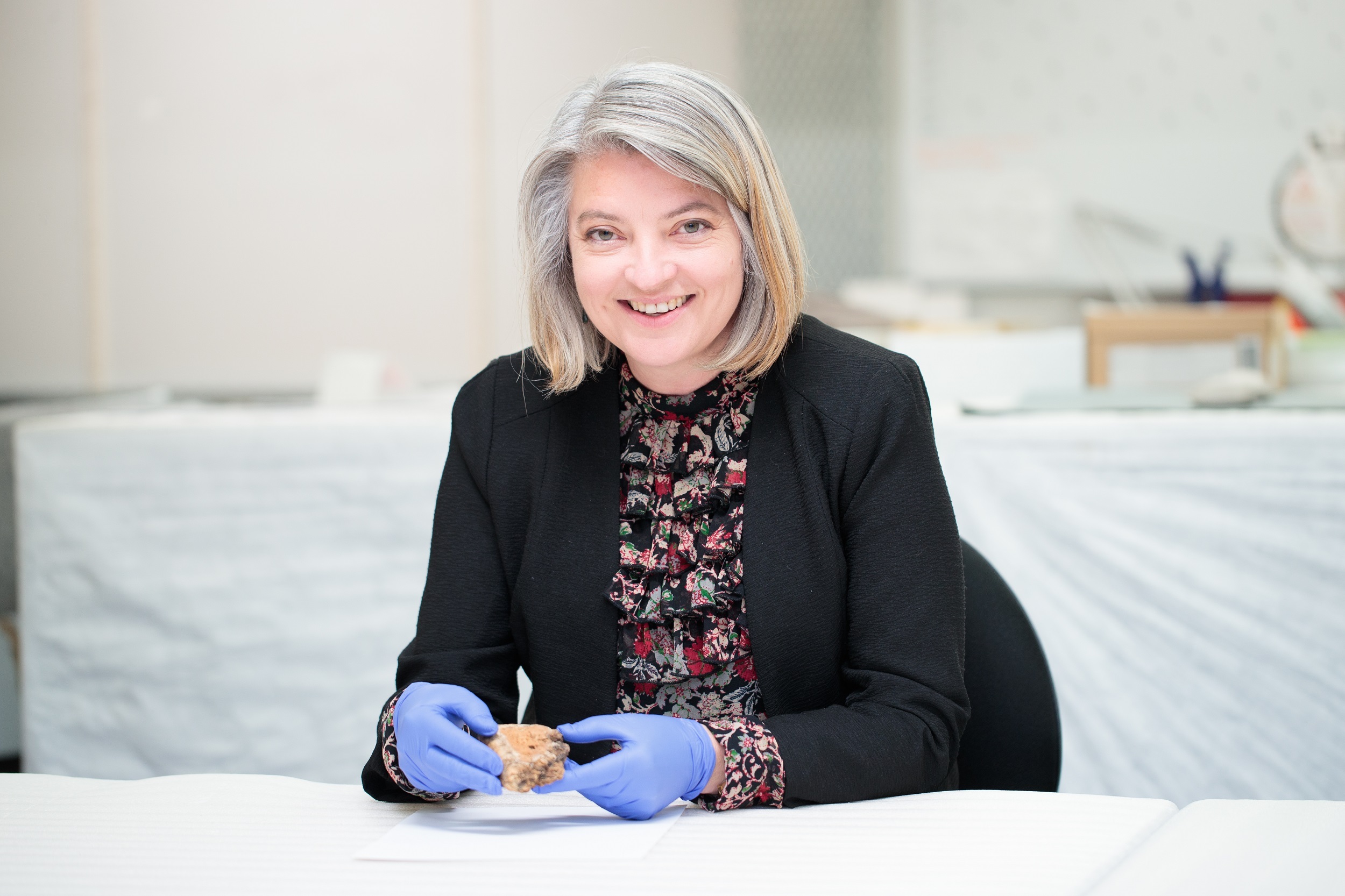 Dr Jill Haley, the study's lead author, holds a Spratt's dog cake fragment from Canterbury Museum's collection.