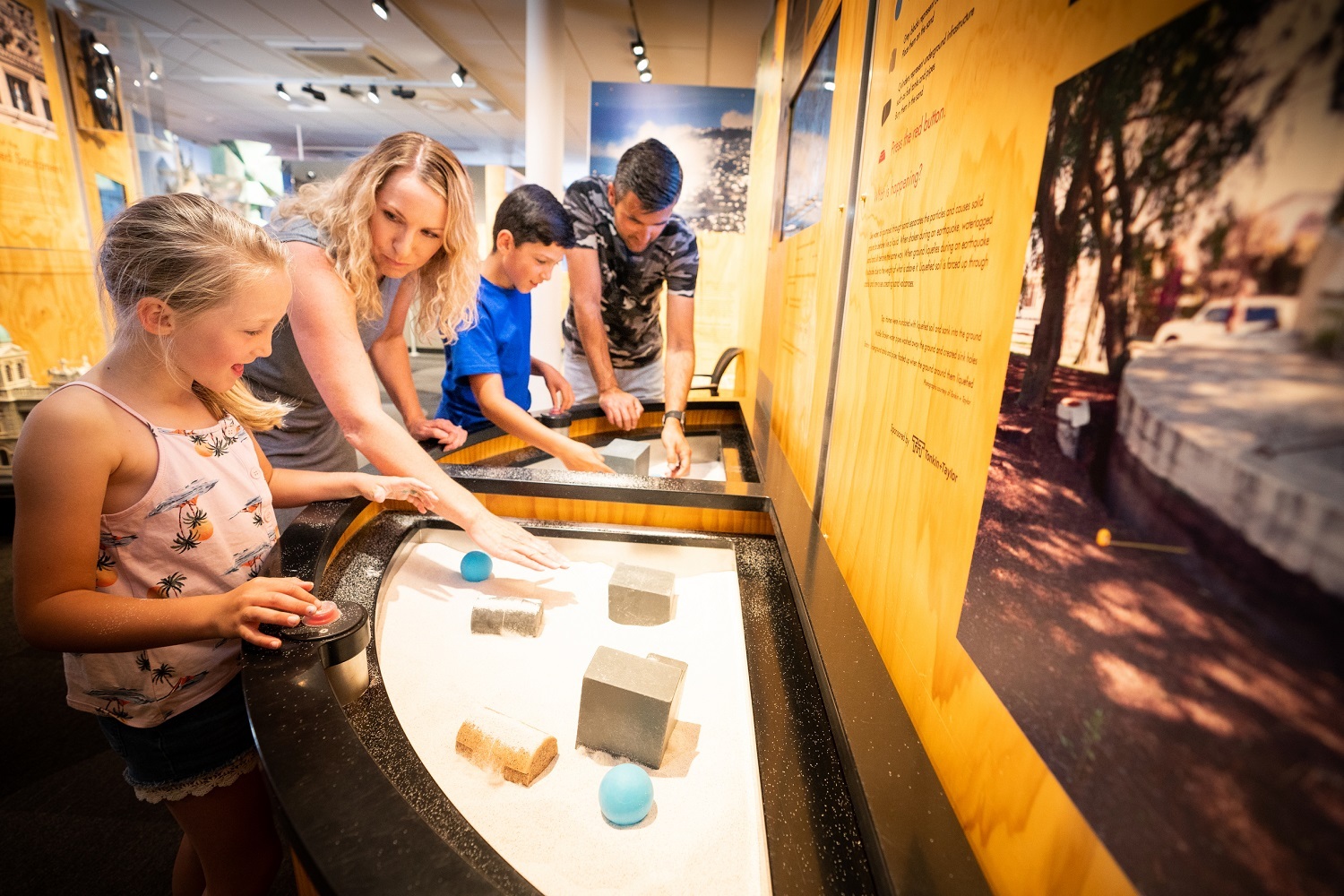 Visitors test out the liquefaction simulator at Quake City