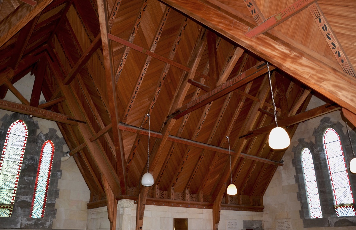 The roof space at St Luke's. As well as red and black kōwhaiwhai designs on the rafters, biblical quotes were painted on other timbers in gold lettering. A fretwork frieze in a Māori pattern runs the perimeter where the roof and walls meet. Photograph by the author, 2016. All Rights Reserved