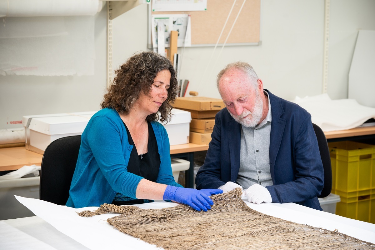 Senior Curator Human History Julia Bradshaw and Emeritus Curator Roger Fyfe examine one of the kupenga (nets). Canterbury Museum E139.74